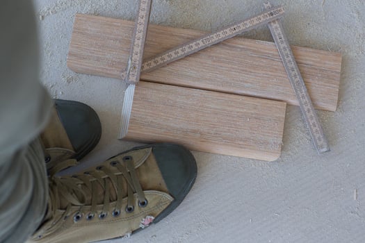 Wooden plinth, measurement band, worker's shoes. Top view photo