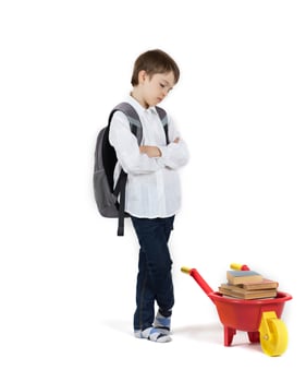 Schoolboy pushes plastic wheelbarrow full of books. Free space for a text. photo