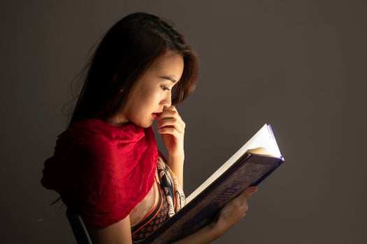Asian woman opening mystic book box magical light dark background photo
