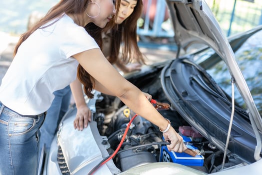 Two Asian people try to check the car engine and wait for assistance after a car breakdown on street. Concept of a vehicle engine problem or accident and emergency help from a Professional mechanic photo