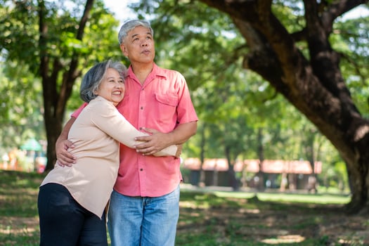 Portrait of lovely elderly couple hugging each other with love and happiness in a park outdoor. Happy smiling Elderly couple enjoying with positive emotions at garden photo