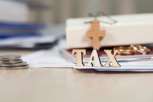 Word TAX composed of wooden letters in front of marriage golden rings. photo