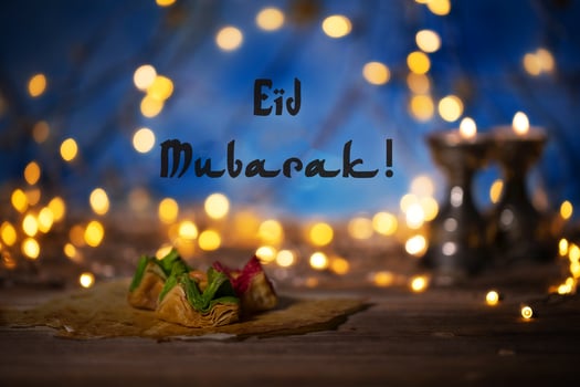 Congratulation Eid Mubarak Arabic sweets on a wooden surface. photo