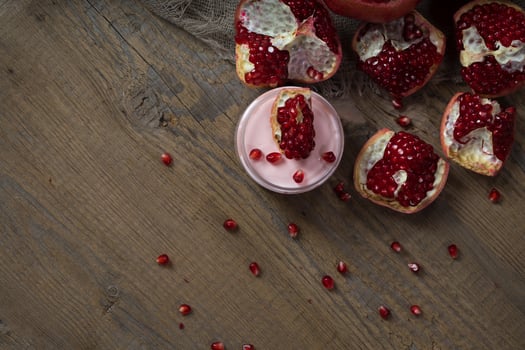Pomegranate body cream on a wooden surface. photo