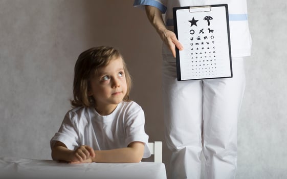 Ophthalmologist checks vision of 5 years old boy photo