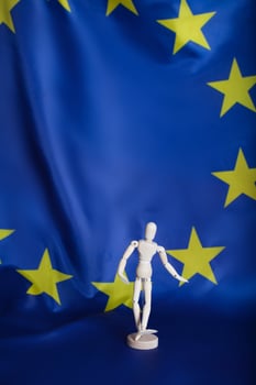 Wooden dummy figurine on European flag. photo