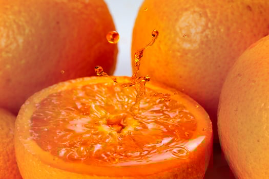 Orange real juice splash over fresh half cut fruit photo