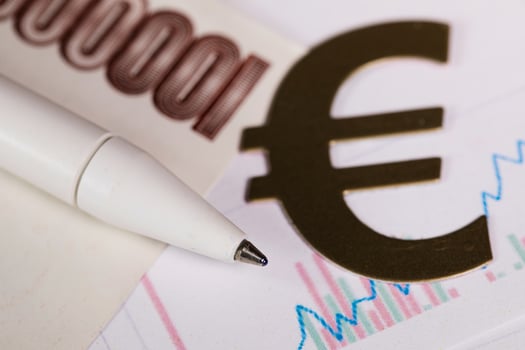 Pen on a banknote. Cutout of euro sign in the background. photo