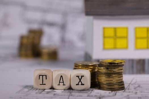 Word TAX composed of wooden letter. Small paper house in the background. photo
