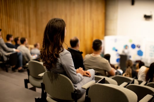 Young woman sitting in audience on conference or workshop photo