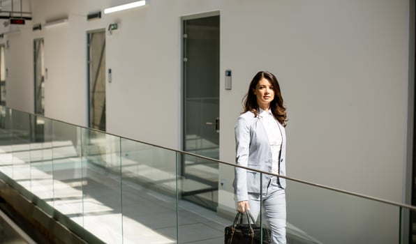 Young business woman walking with briefcase in the office hallway photo