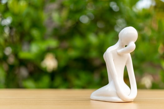 Ceramic Yoga Figurine of Woman doing yoga pose on wooden floor and green leaf  background photo