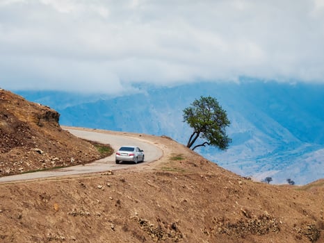 Mountain serpentine road loop. Morning mountain valley with a serpentine road. Silver car on a mountain serpentine. photo