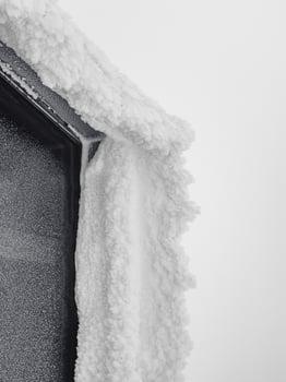 Winter ice window. Icy window to winter in snow. Icy visor over the window. Vertical view. photo