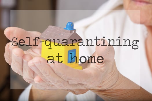 Self-quarantining at home. Senior woman and mini rubber house in the background photo
