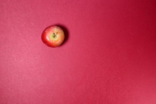 Small mini red apple on red background photo