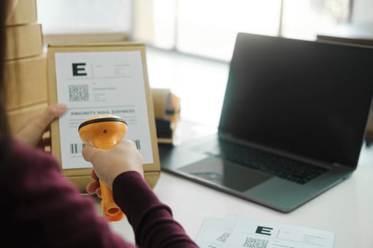 Female online business owner scan shipping label on parcel. photo