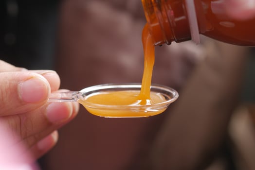 pour liquid medicine on top of spoon photo