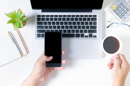 Business man holding smart phone and hot coffee photo