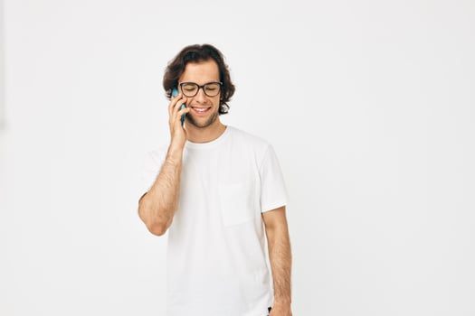 Attractive man in a white T-shirt communication by phone isolated background photo