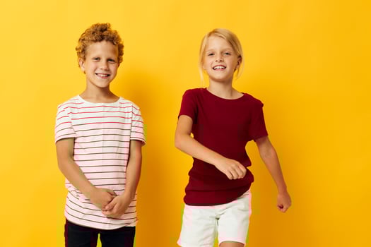 Boy and girl casual wear games fun together yellow background photo