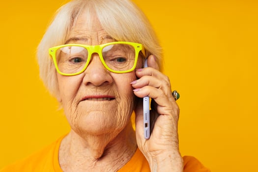 smiling elderly woman happy lifestyle in yellow t-shirts with phone close-up emotions photo