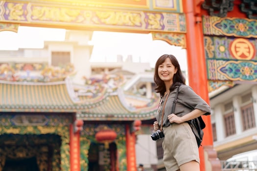 Young Asian woman backpack traveler enjoying China town street food market in Bangkok, Thailand. Traveler checking out side streets. photo