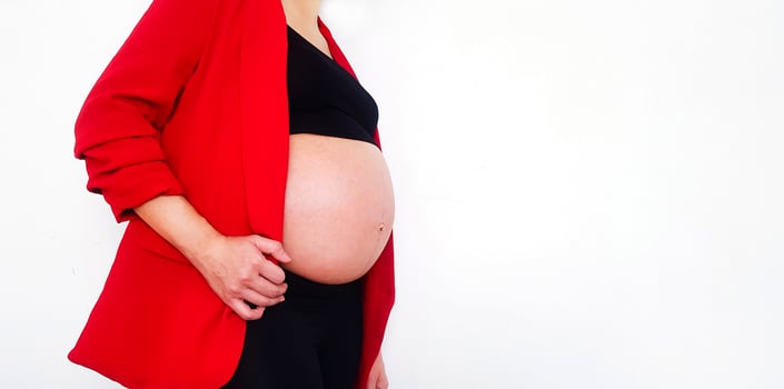 Pregnant woman wearing red suit show swollen belly isolated on white background and copy space with clipping path. Pregnancy 7-9 months, motherhood, love, expectation and car photo
