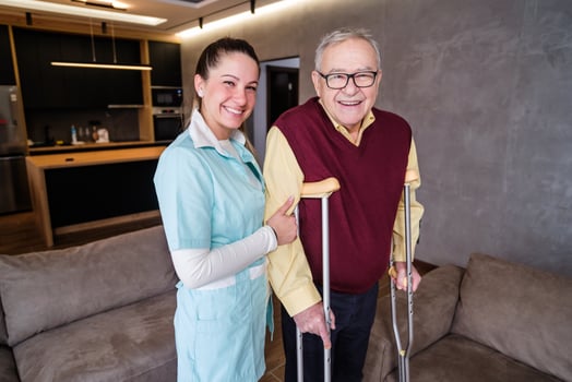 Nurse home caregiver is assisting old man at his home. Professional health support for elderly people. photo