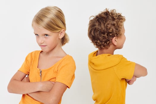 Small children in yellow t-shirts standing side by side childhood emotions light background unaltered photo