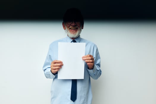 elderly man holding documents with a sheet of paper light background photo