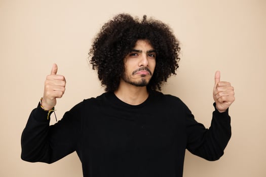 man with curly hair in a black sweater hand gesture isolated background photo