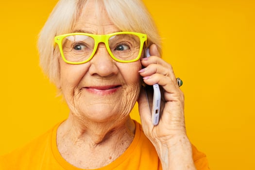 smiling elderly woman in casual t-shirt communication by phone close-up emotions photo