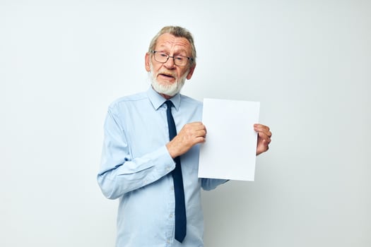 old man holding documents with a sheet of paper light background photo