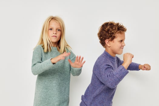 Portrait of cute children in multi-colored sweaters posing for fun light background photo