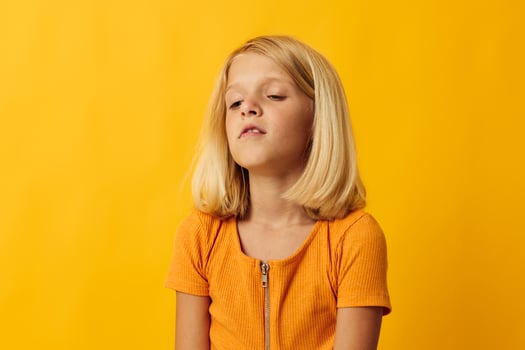 little blonde girl holding her head emotions surprise photo