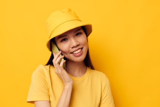 woman in a yellow hat and T-shirt talking on the phone Monochrome shot photo