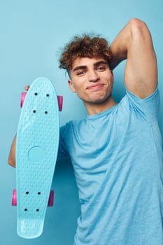 kinky guy skateboard in hand in blue t-shirts isolated background photo