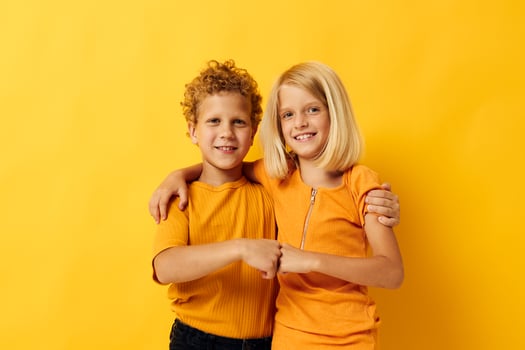 Portrait of cute children cuddling fashion childhood entertainment on colored background photo