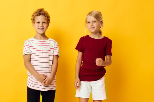 two joyful children cuddling fashion childhood entertainment yellow background photo
