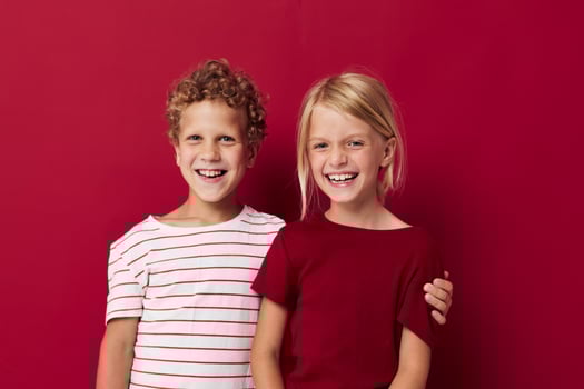 two joyful children emotions stand side by side in everyday clothes isolated background photo