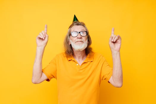 Portrait elderly man in a yellow t-shirt with a cap on his head fun cropped view photo