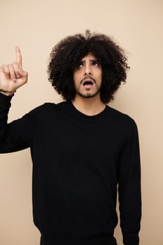 man with curly hair in a black sweater hand gesture isolated background photo