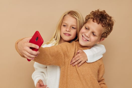 Little boy and girl with a red phone together technologies isolated background photo