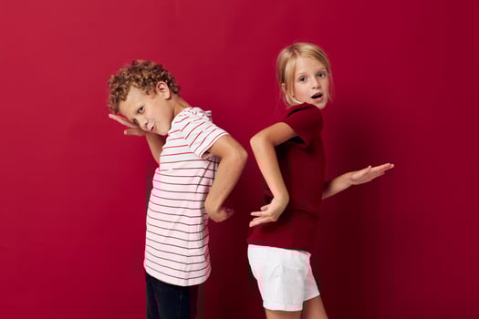 Cute preschool kids emotions stand side by side in everyday clothes red background photo