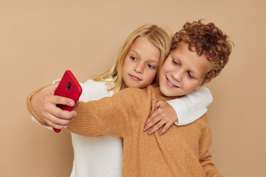 Little boy and girl with a red phone together technologies isolated background photo