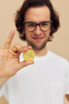 Attractive man with glasses gold bitcoin in hands Lifestyle unaltered photo