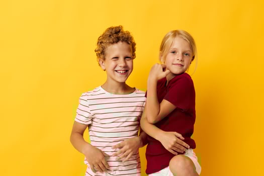 Boy and girl casual wear games fun together yellow background photo