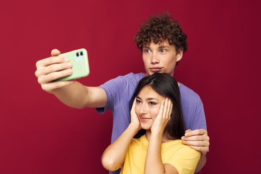 Man and woman modern style emotions fun phone red background photo