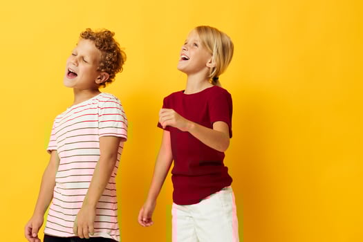 Boy and girl standing side by side posing childhood emotions isolated background photo